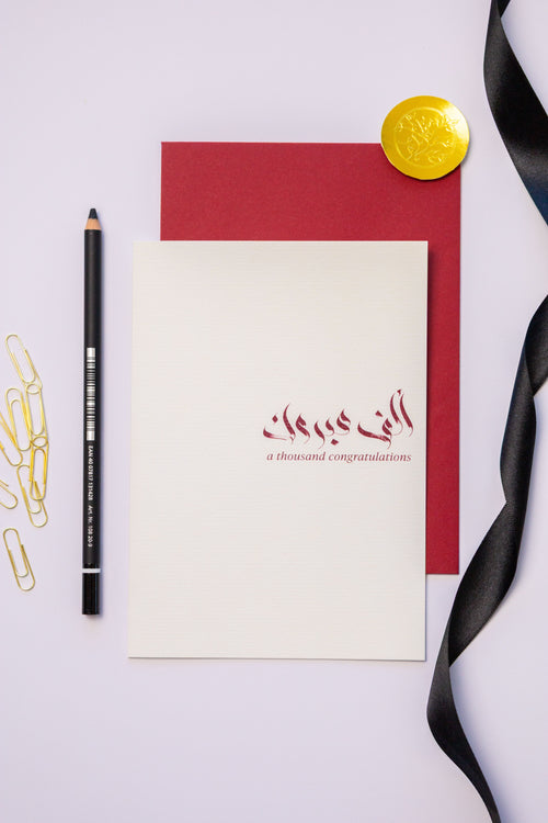 Greeting card with Arabic text, pencil, and decorative elements on a light background